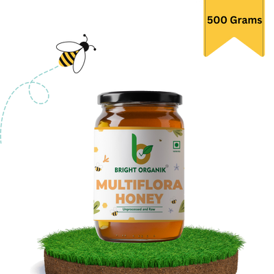 multiflora honey in a 500 grams jar on grass top and honey bee flying nearby